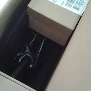 partially packed bicycle visible inside large open shipping box